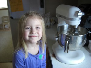 Isabelle helping make birthday cupcakes